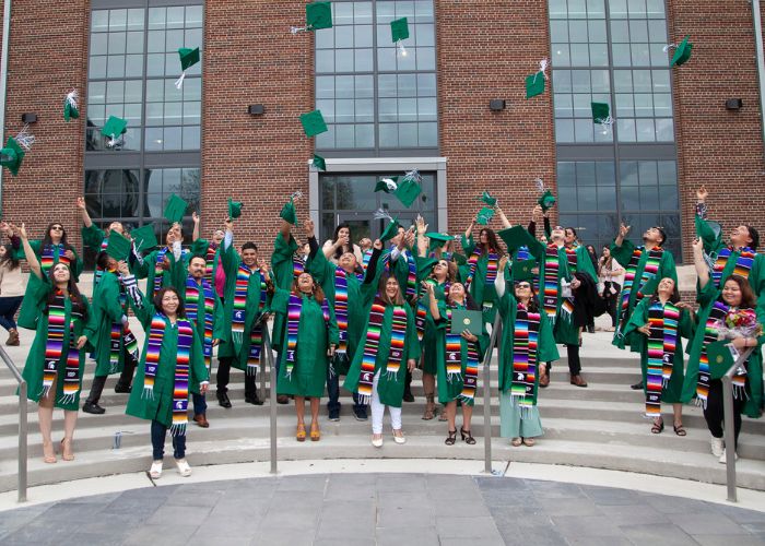 Image of MSU CAMP graduates in caps and gowns celebrating graduation.